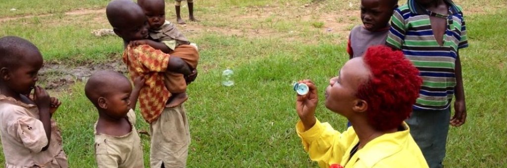 En clown blåser såpbubblor, ett par barn tittar på