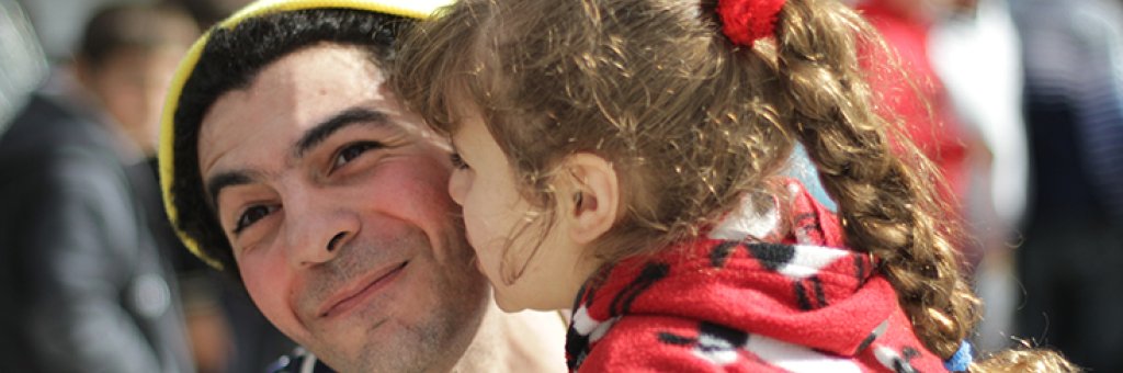 En clown får en puss på kinden av ett barn