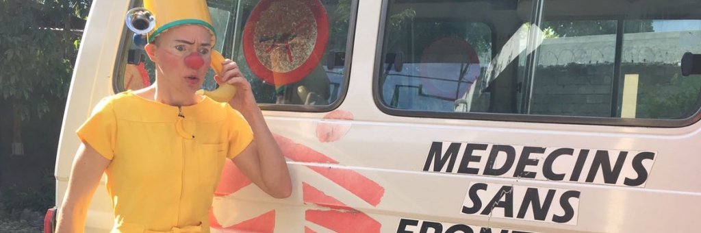 Clown i gula kläder använder en banan som telefon