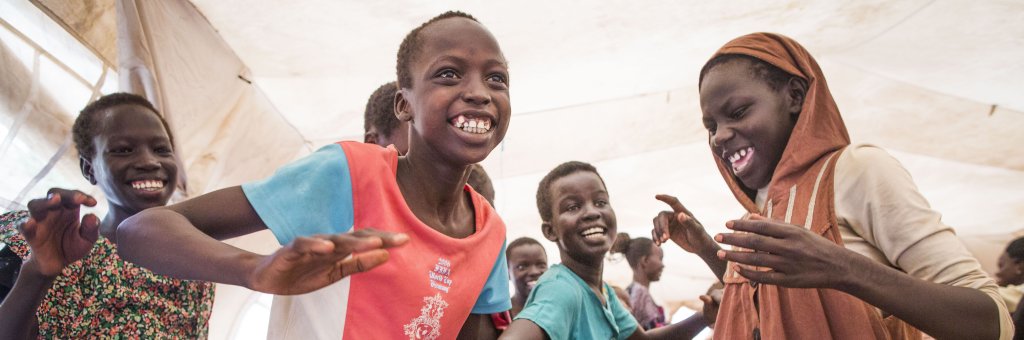 En grupp barn dansar och ler