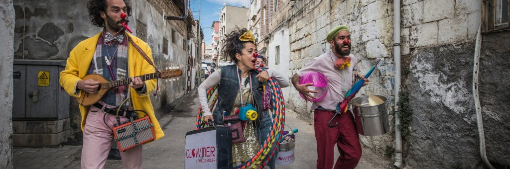 Fyra artister som bär på rockringar, gitarr osv och går i en gränd