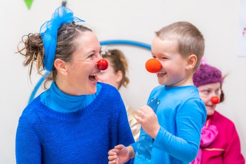 En artist och barn med clownnäsa på