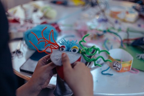 Ettbarn skapar en färgglad docka med filt och piprensare