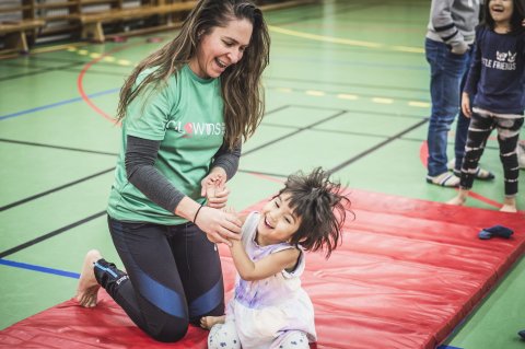 Marina och ett barn på mattan för kullerbyttor