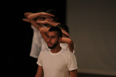 Foto på Rami Aboushi när han står på scen i en vit t-shirt