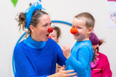 En clown och ett barn, båda med röda näsor på