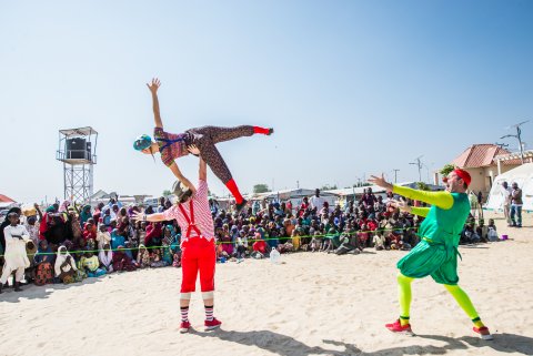 En artist som lyfter upp en annan över huvudet framför en publik