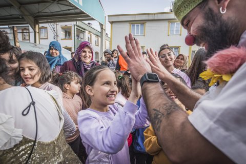 Ett barn och clown gör high five och skrattar