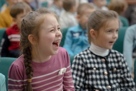 Två flickor i publiken, den ena gapskrattar