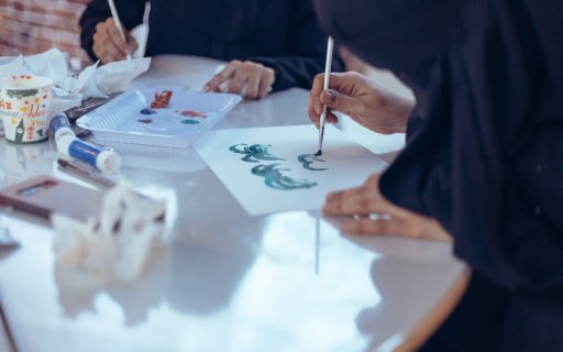 Händer som målar med pensel och färg