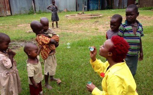 En clown blåser såpbubblor, ett par barn tittar på