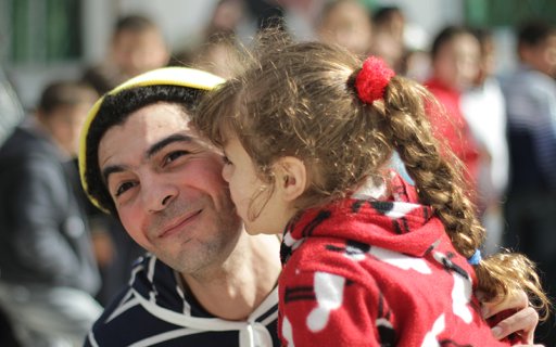 En clown får en puss på kinden av ett barn