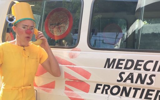 Clown i gula kläder använder en banan som telefon