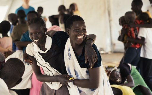 Två flickor håller om varandra och ler