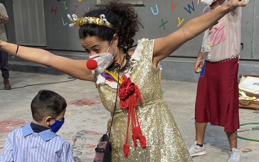 Clown i guldklänning uppträder
