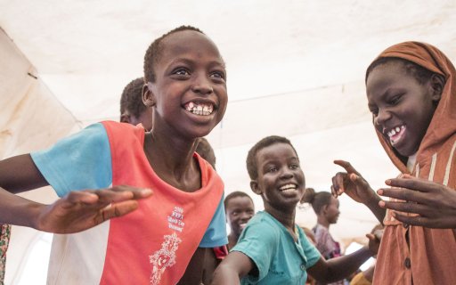 En grupp barn dansar och ler